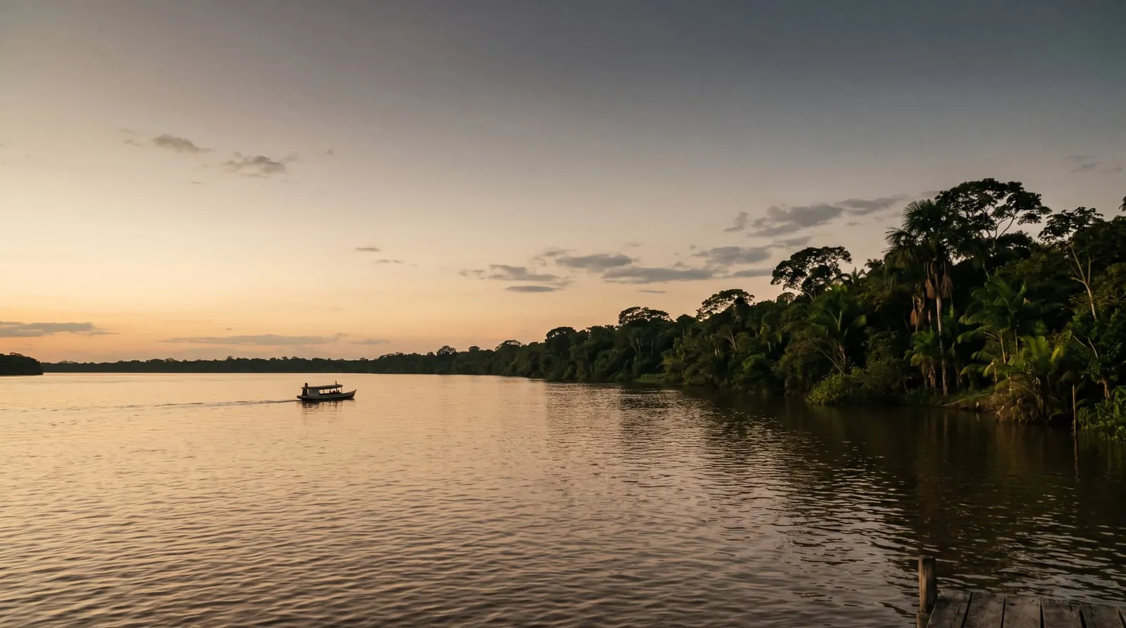 Rio Maguari ao entardecer, com margens de mata densa e uma pequena embarcação ao longe.